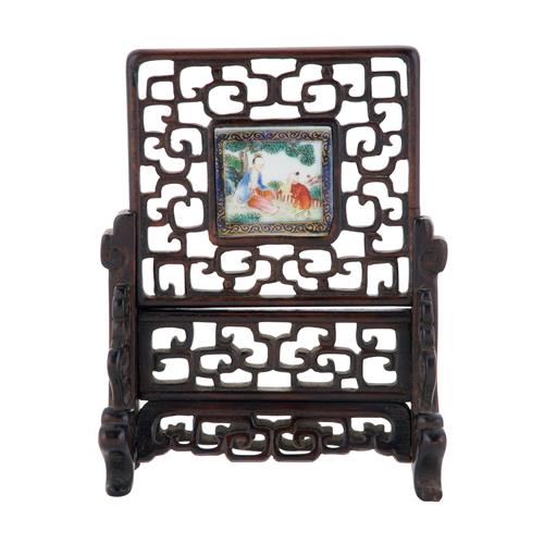 84 · A MINIATURE CARVED AND PIERCED CHINESE HARDWOOD TABLE SCREEN WITH INSET PORCELAIN PANEL