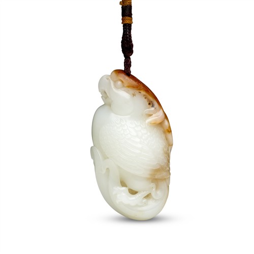 65 · A CHINESE WHITE AND RUSSET JADE PARROT, QING DYNASTY (1644 - 1911)