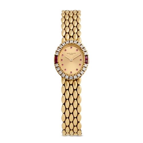 80 · PATEK PHILIPPE REF 4752/21 A LADY'S 18CT GOLD RUBY AND DIAMOND-SET BRACELET WATCH WITH SIGMA DIAL CIRCA 1990