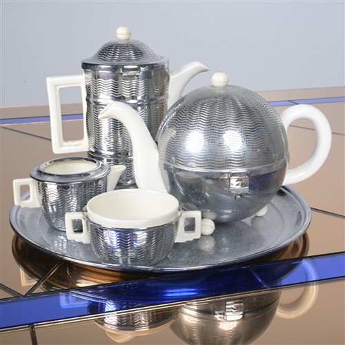 AN ART DECO ENGLISH PORCELAIN AND METAL PART TEA SET BY HEATMASTER, INCLUDING A TEAPOT, COFFEE POT AND CUP AND MATCHED SERVING TRAY.